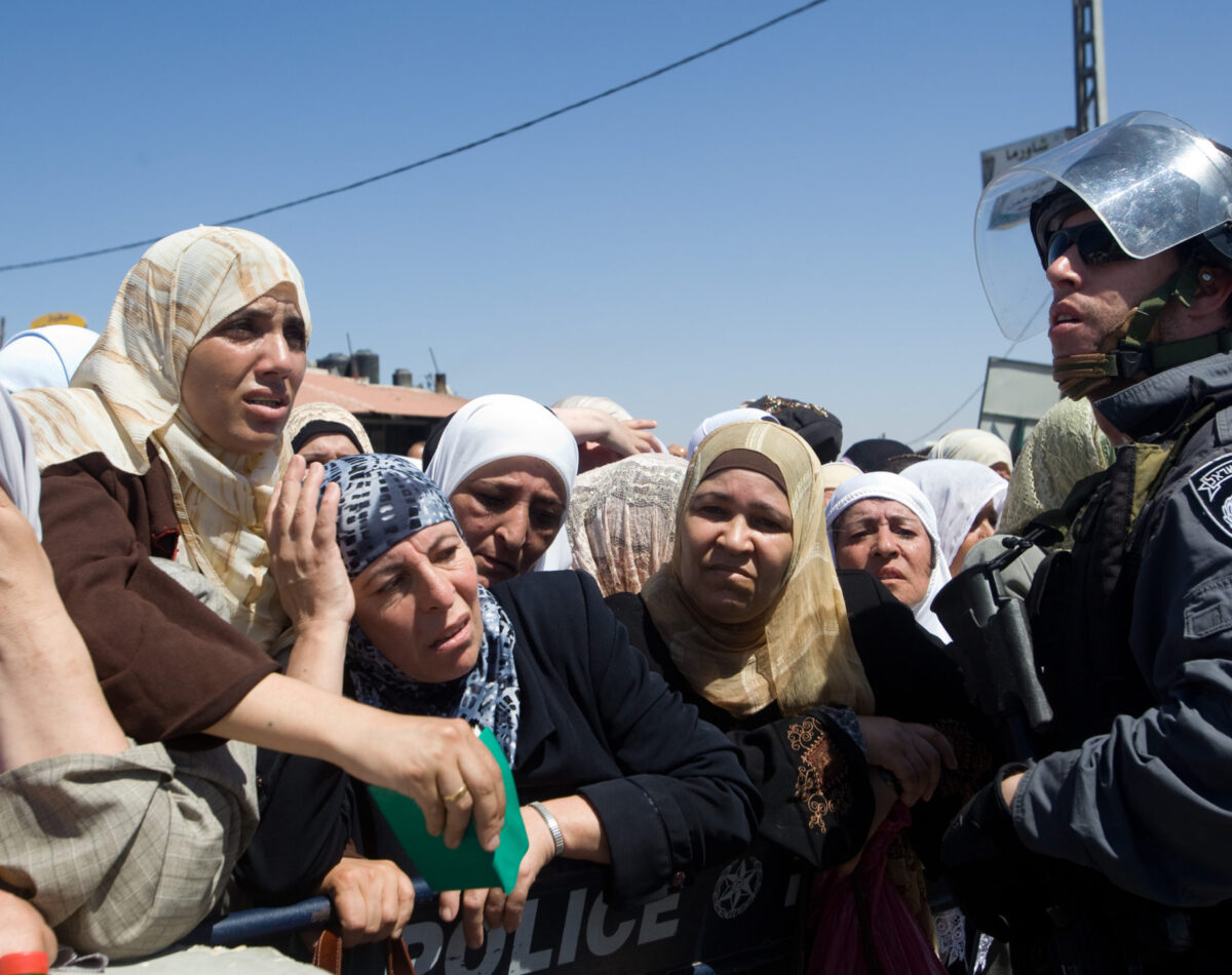 Palestinian women waiting at a checkpoint for Friday prayers