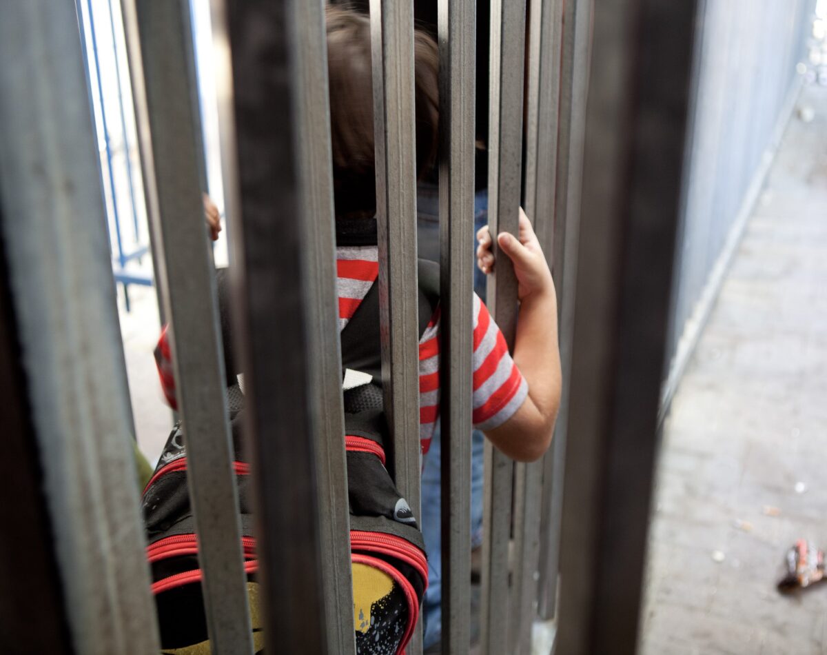 A Palestinian child waits at a checkpoint