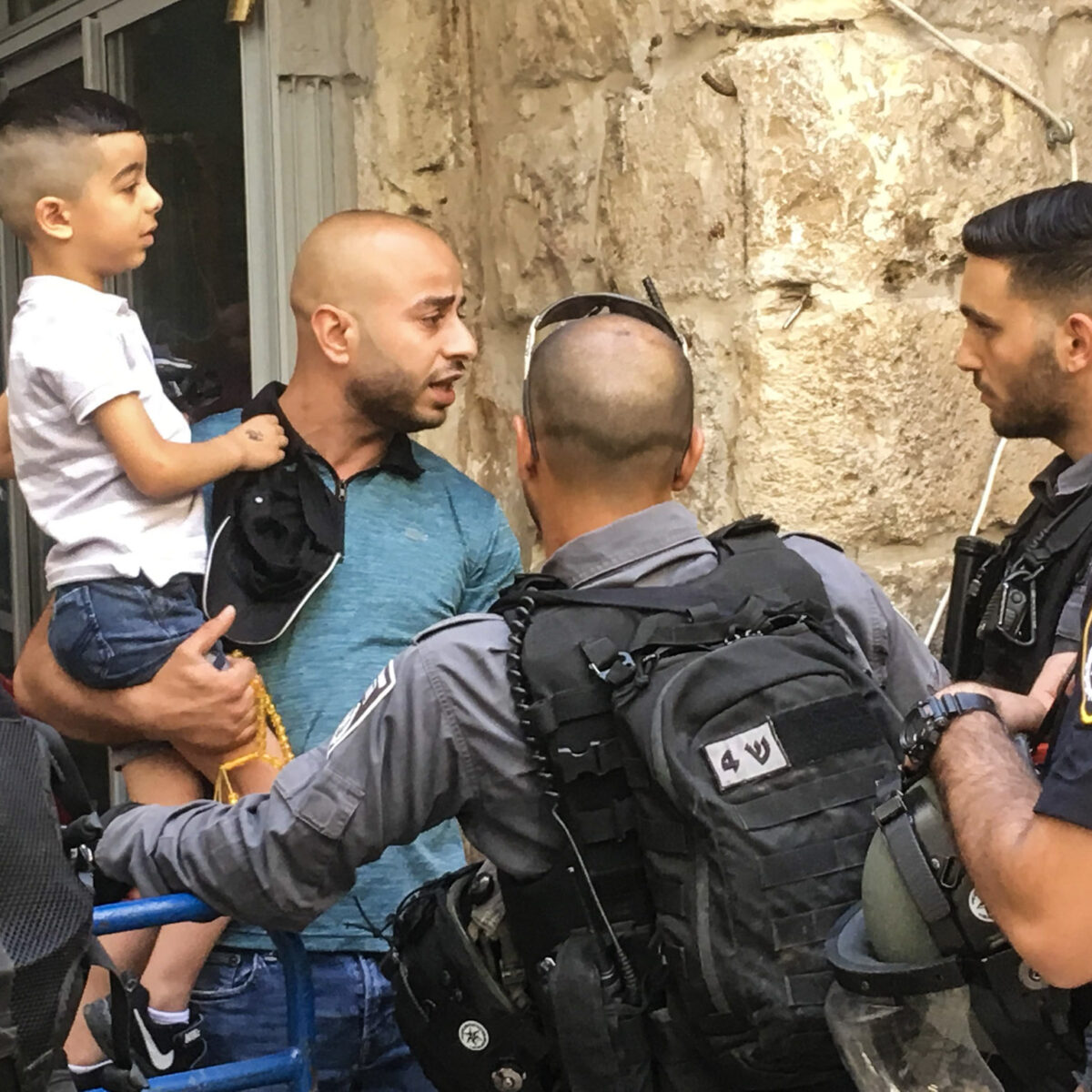 Israeli soldiers prevent a Palestinian man from accessing his street in the Old City on 'Jerusalem Day'