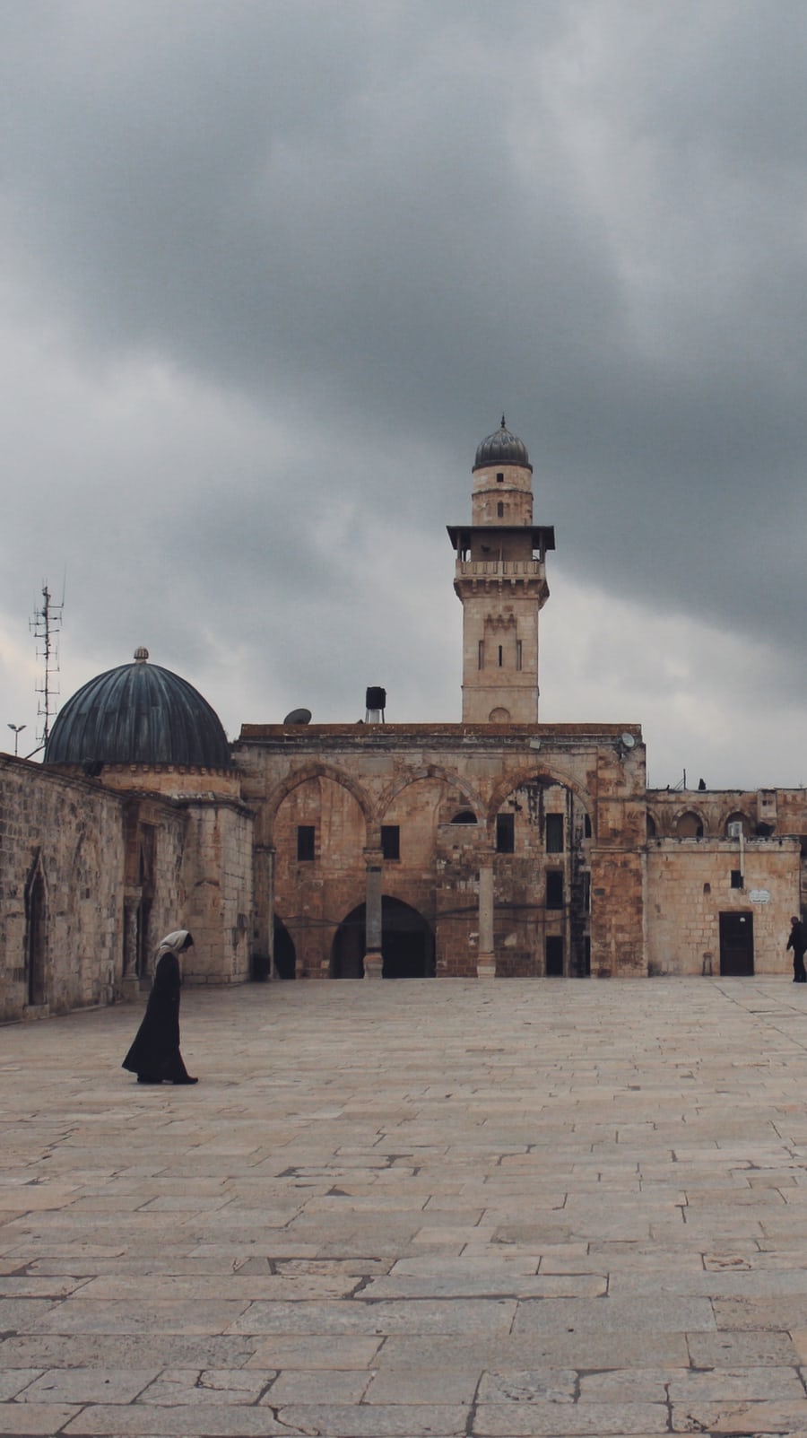 Palestinian Muslim woman walks past a mosque in Jerusalem
