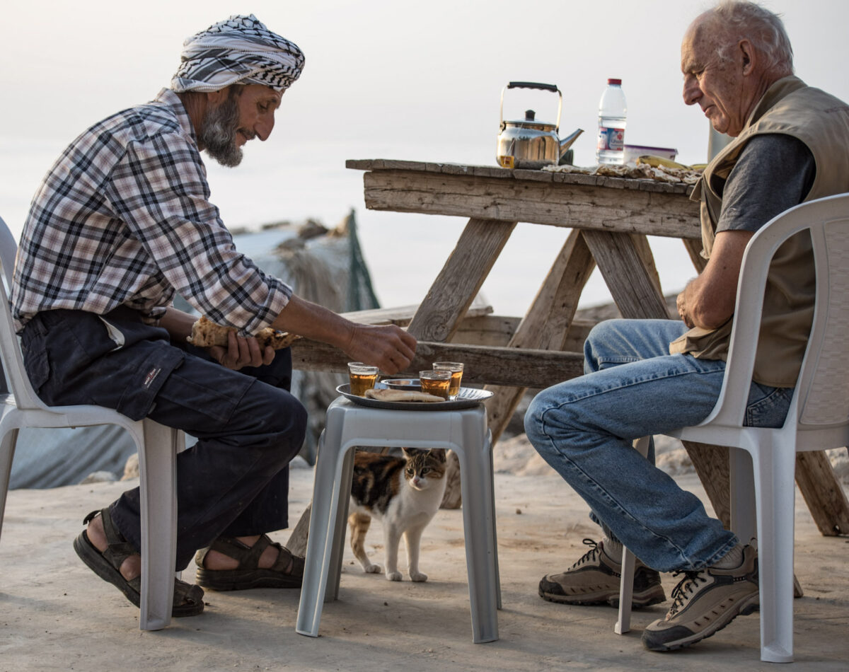 An EA drinks tea with a Palestinian man