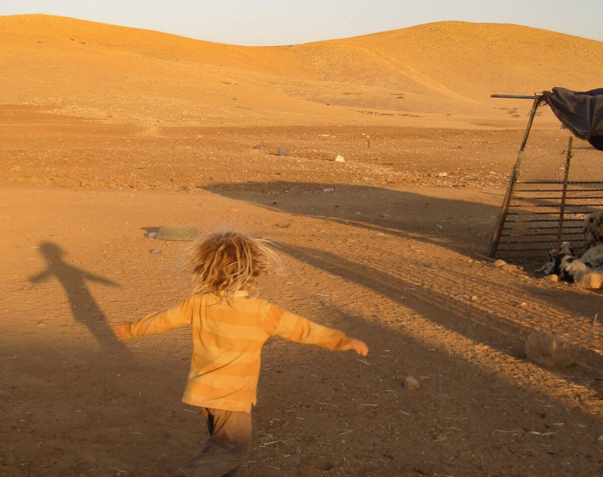 A Palestinian child plays with her shadows in the desert landscape of the South Hebron Hills A Palestinian child plays with her shadows in the desert landscape of the South Hebron Hills