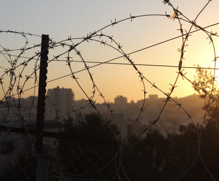 Barbed wire in the foreground, sunset in the background