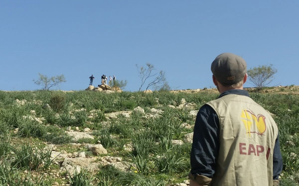 Settlers watch from the road to ensure the shepherds don’t try to cross again