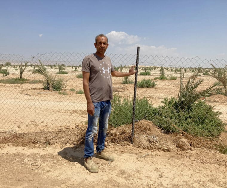 Ibrahim Damras stands in front of his land taken for a settlement date plantation in 2021