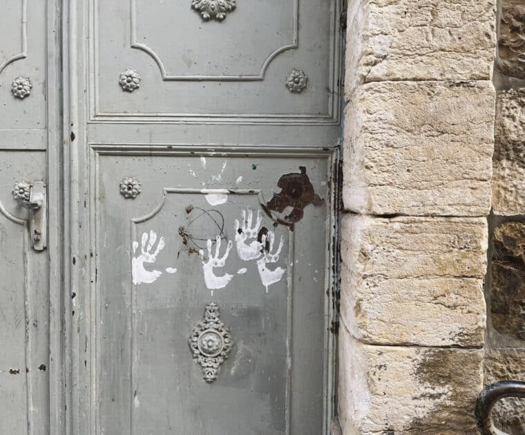 Painted childrens handprints on a doorway in Palestine